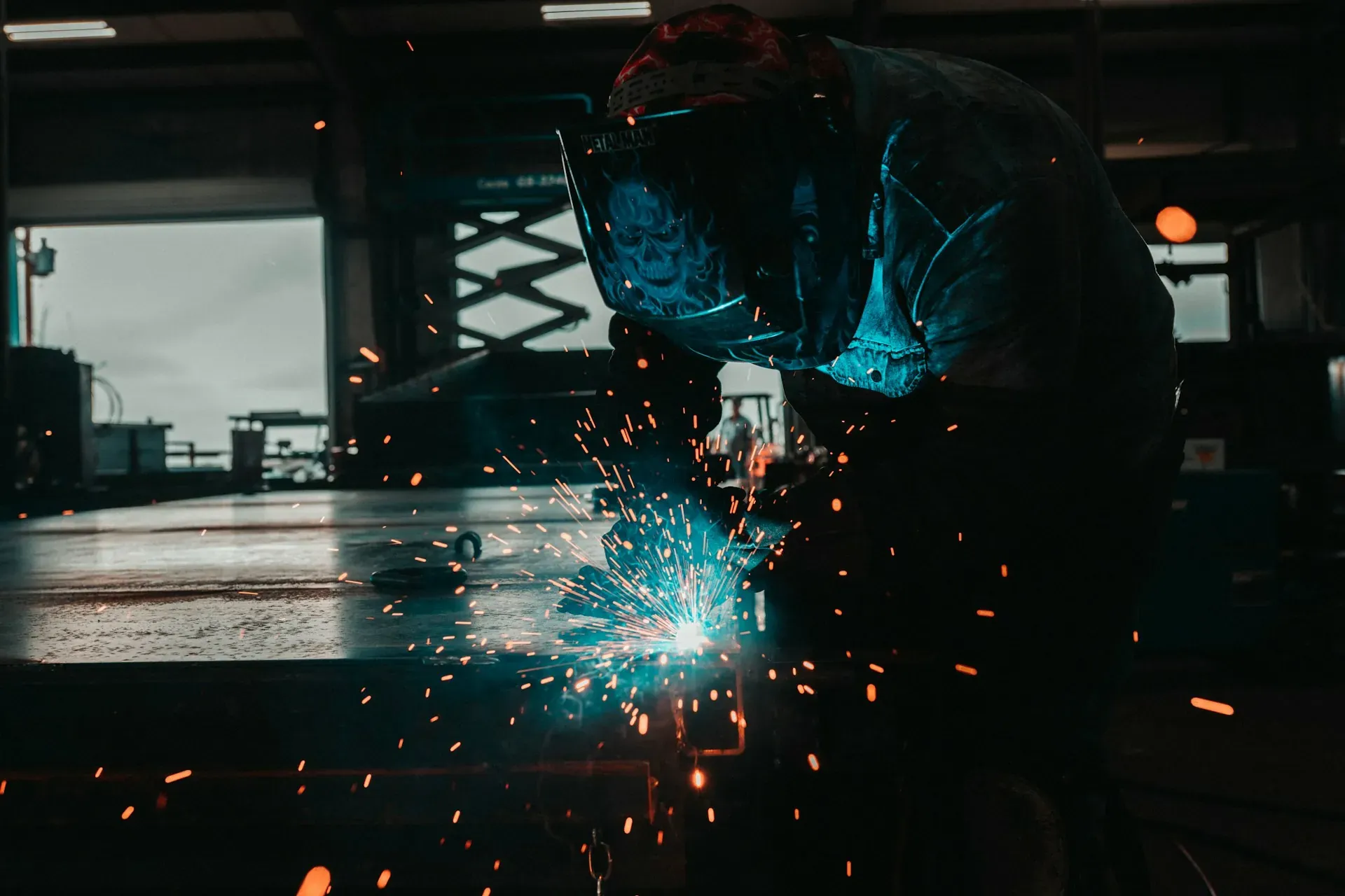 An image of a welder building something in his workshop
